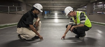 two engineers inspect the floor of a building